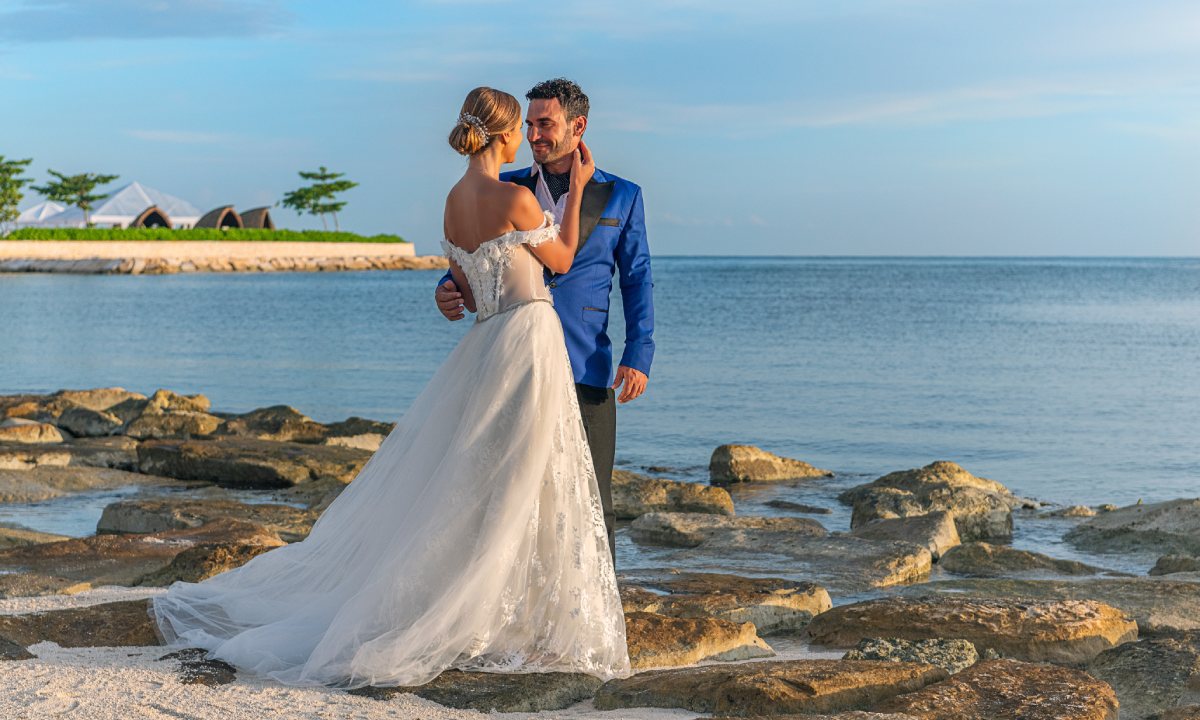 Groom and bride on rocks by the sea