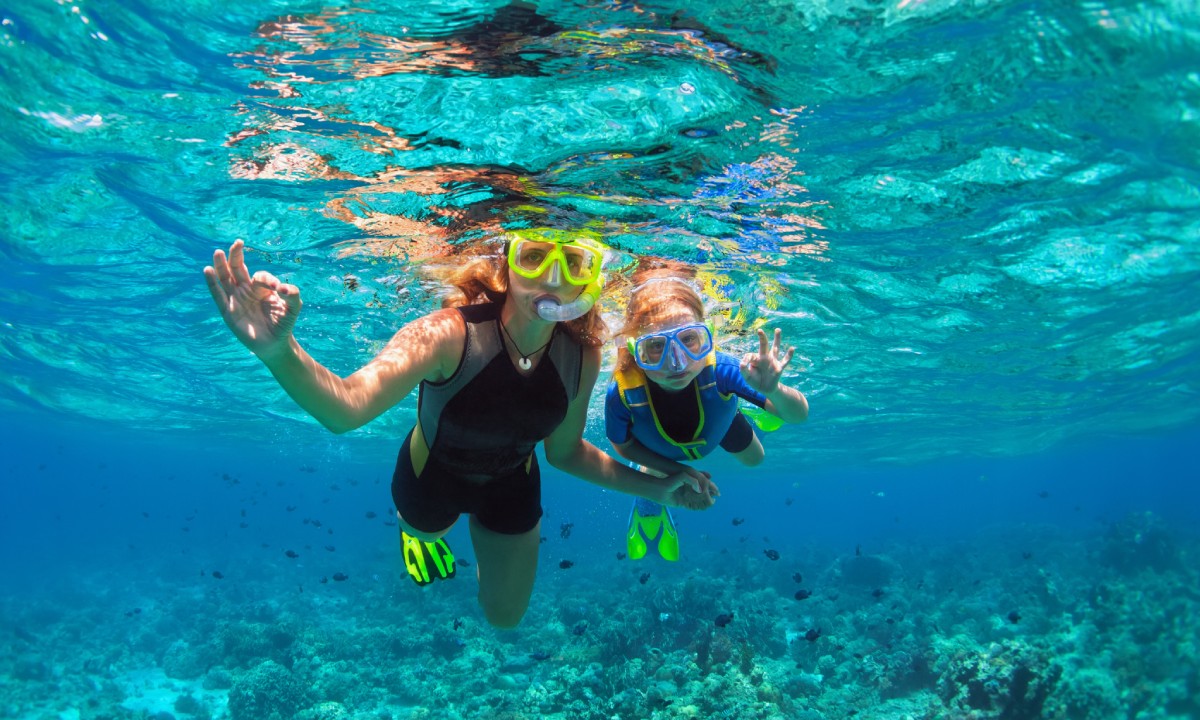 Madre con hija haciendo snorkel