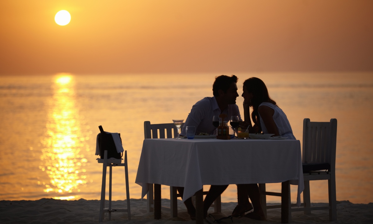 Paar beim Abendessen im Sand am Meer