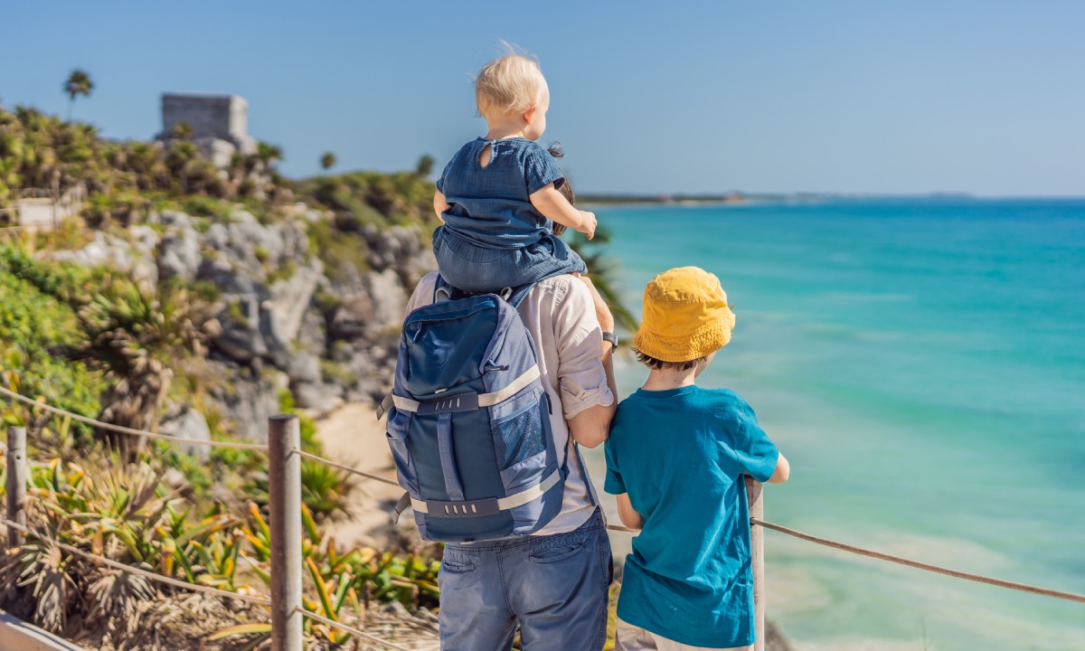 Padre con hijos de ruta junto al mar
