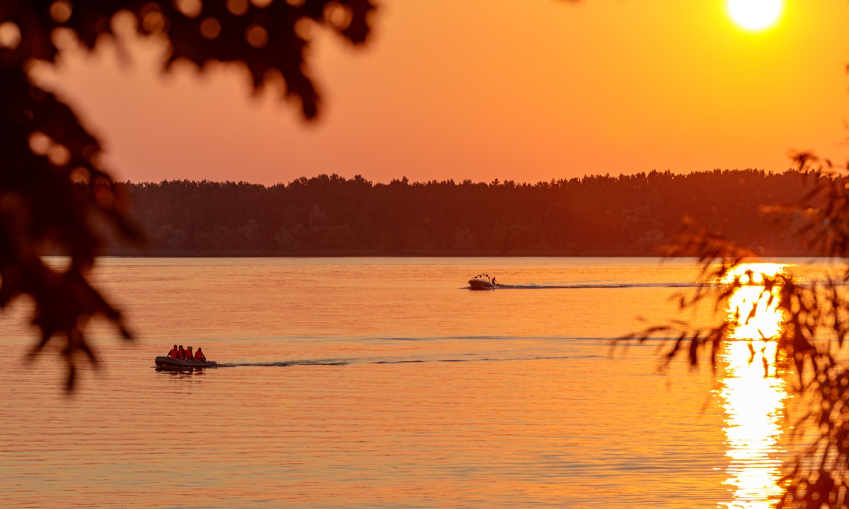 Boote fahren bei Sonnenuntergang auf der Lagune Nichupté