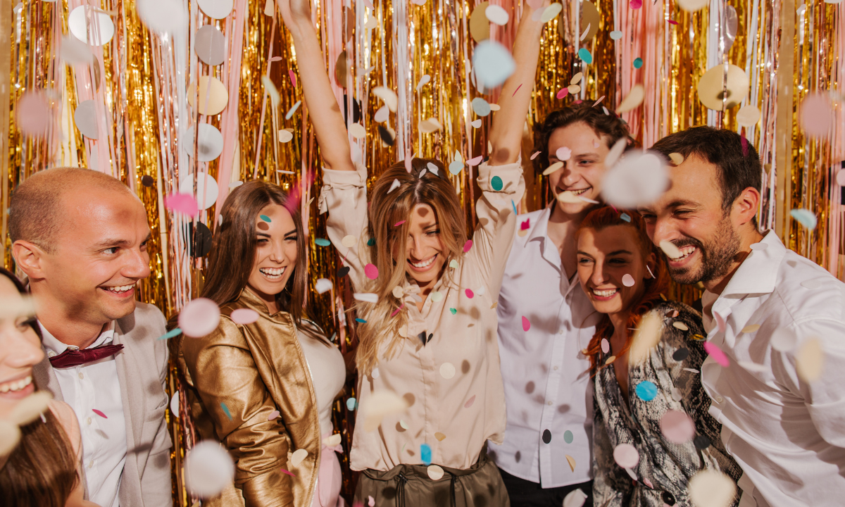 Group of friends celebrating New Year’s Eve with confetti