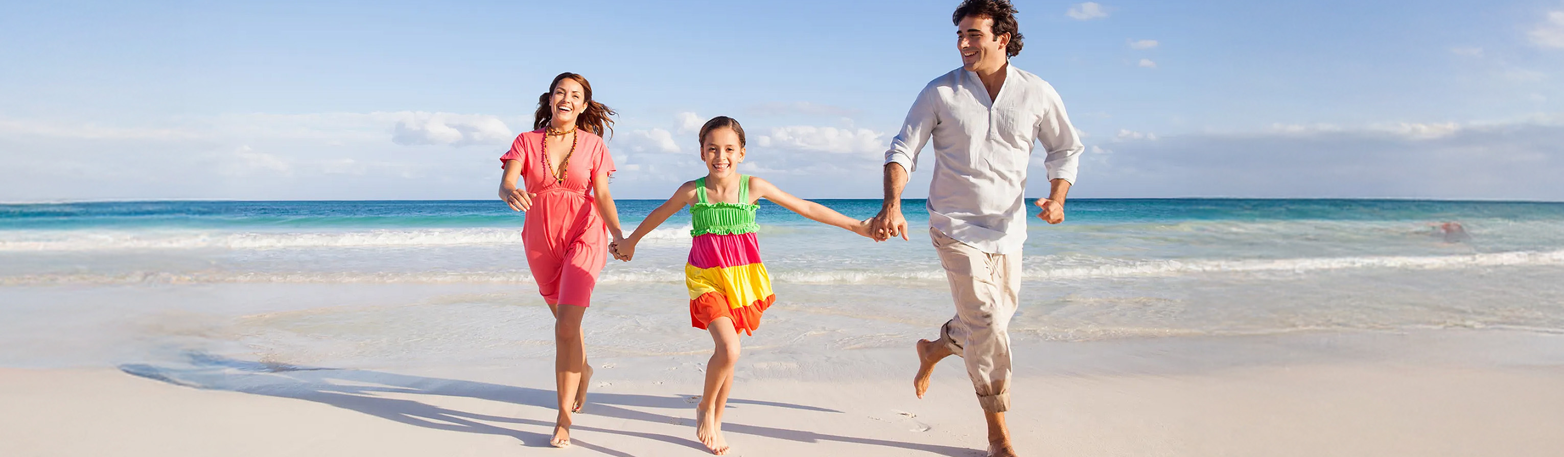 Padres con hija en la orilla del mar