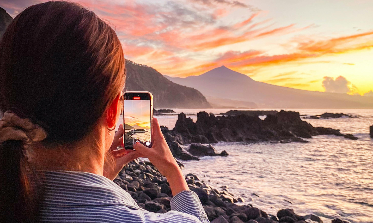 Mujer capturando el atardecer en Tenerife
