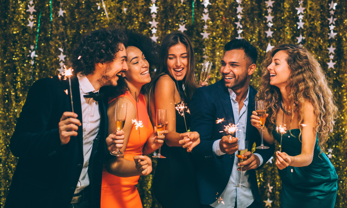 Personas celebrando el Fin de Año con bengalas y champán
