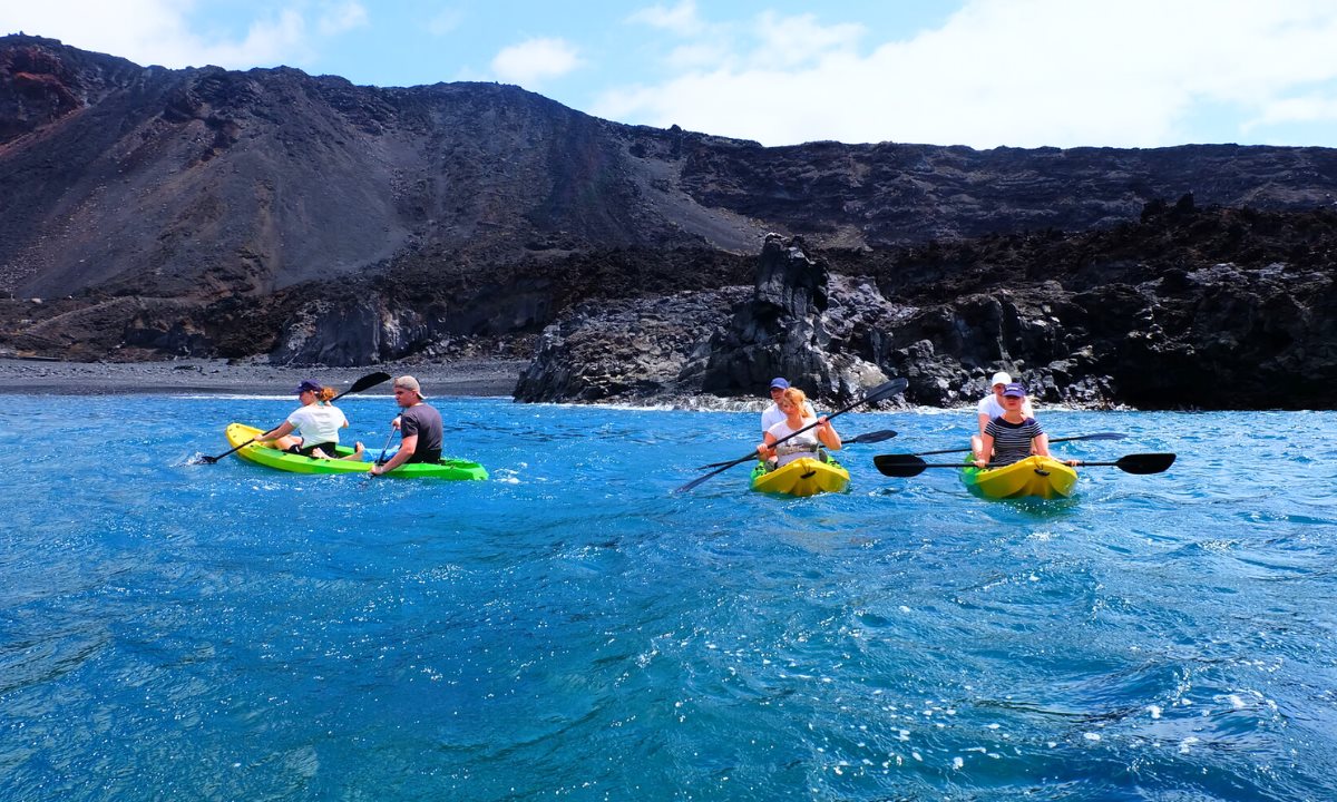 People kayaking along the volcanic coastline of La Palma
