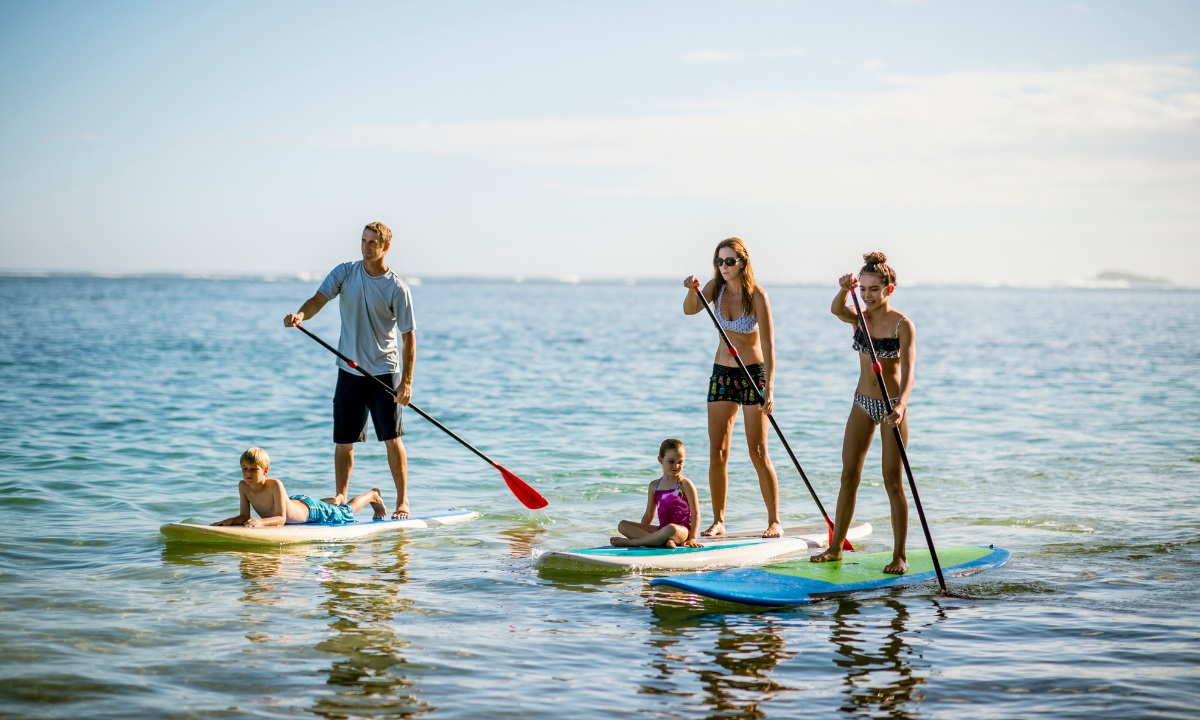Group of people paddle boarding on calm waters