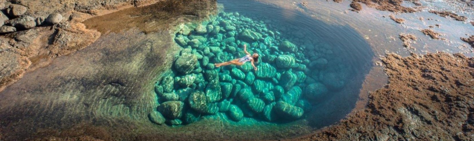 Woman floating in the natural pool at Caleta de Fuste in Fuerteventura