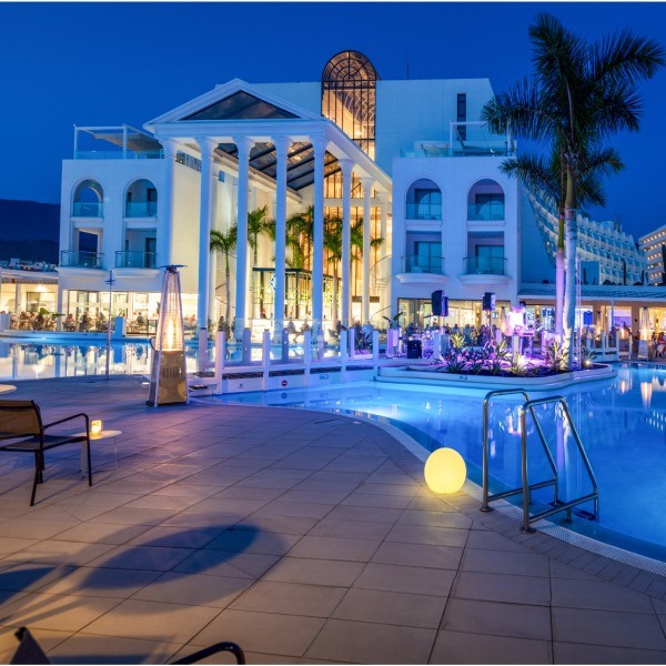 Illuminated pool at Guayarmina Princess hotel with live music and cozy night ambiance